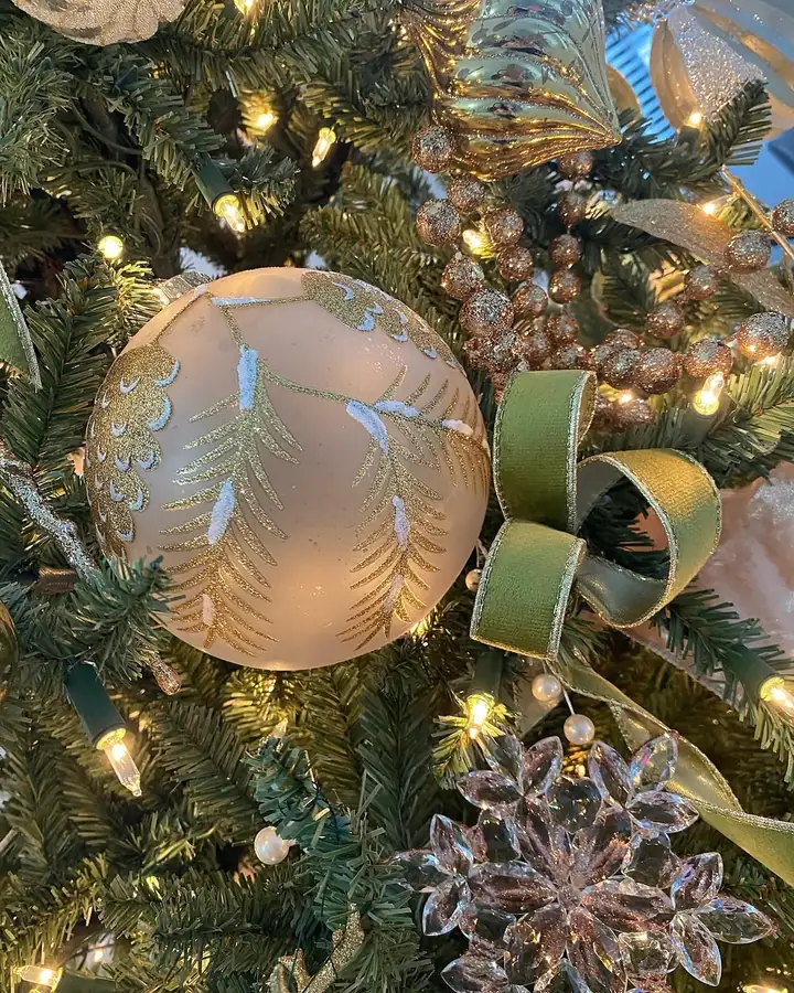 A champagne glass ornament with a sage velvet ribbon on a Miami tree