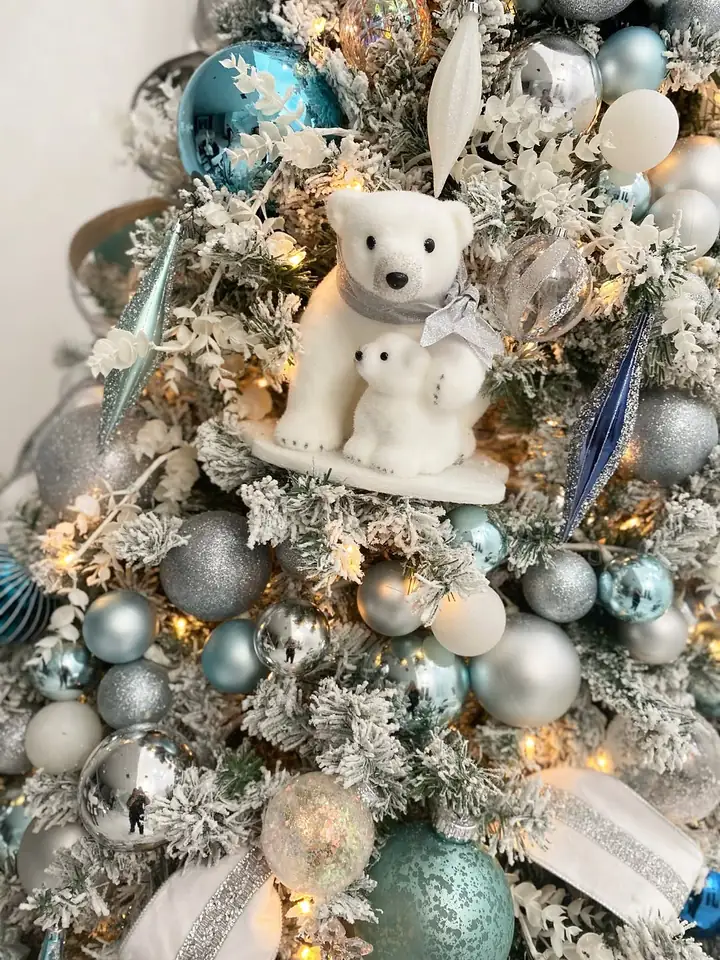 Two flocked polar bears among silver and pale blue ornaments