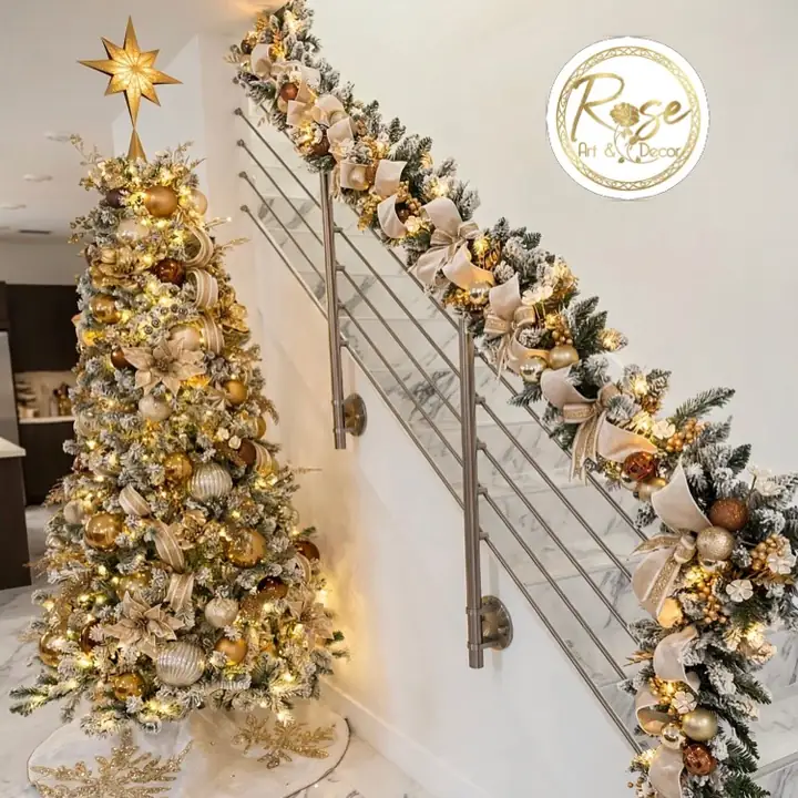 Gold and champagne garland running down a modern staircase railing beside a flocked Christmas tree