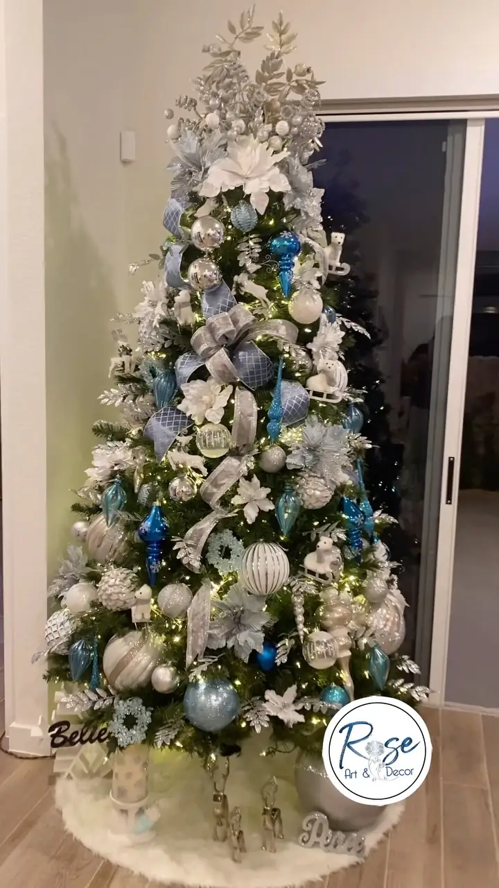 A complete blue, silver and white Christmas tree by Rose Art and Decor in a Miami living room