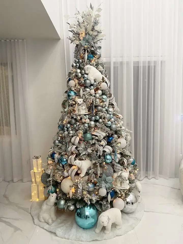 Flocked white Christmas tree with icy blue ornaments and polar bears in a Miami home